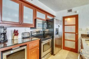 a kitchen with wooden cabinets and stainless steel appliances at San Luis 935-Luis Lookout in Galveston