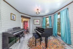 a piano in a living room with blue curtains at Castle House in Ruidoso