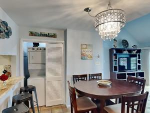 a kitchen and dining room with a table and a chandelier at Cozy Coastal Repose in Padre Island