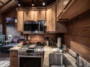 a kitchen with a stove and a microwave at Midtown Riverfront 2 in Ruidoso