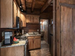 a kitchen with wooden cabinets and a stove at Midtown Riverfront 2 in Ruidoso