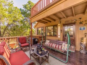 a porch of a house with a couch and a chair at Mockingbird Cabin in Ruidoso