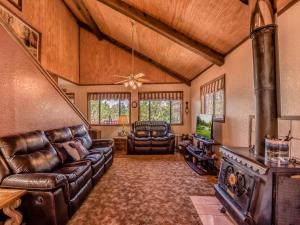 a living room with leather furniture and a fireplace at Mockingbird Cabin in Ruidoso