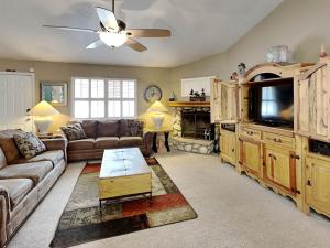a living room with a couch and a flat screen tv at Touch of Santa Fe in Ruidoso