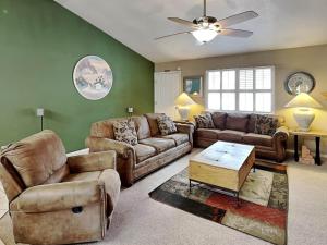 a living room with two couches and a table at Touch of Santa Fe in Ruidoso