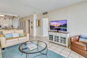 a living room with a couch and a glass table at Galvestonian 1002-Beachfront Getaway in Galveston