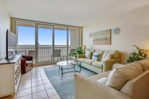 a living room with a couch and a television at Galvestonian 1002-Beachfront Getaway in Galveston