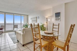 a living room with a table and a couch at Galvestonian 1002-Beachfront Getaway in Galveston