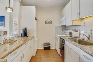 a kitchen with white cabinets and a sink at Galvestonian 1002-Beachfront Getaway in Galveston
