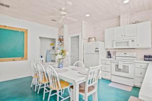 a dining room with a white table and chairs at Above & Beyond in Port Aransas