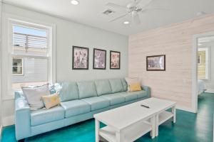 a living room with a blue couch and a table at Above & Beyond in Port Aransas