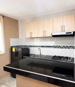 a kitchen with a black counter top and a sink at Hotel Babilonia Boutique in Cúcuta