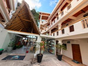 a building with two palm trees in a courtyard at Villas & Suites Santa Monica in Rincon de Guayabitos