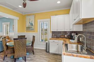 a kitchen with white cabinets and a table and chairs at P Alister Trio in Port Aransas +28 photos