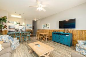 a living room with a blue cabinet and a kitchen at Lets Padre at Village by the Beach in Padre Island
