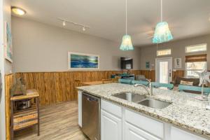 a kitchen with a sink and a living room at Lets Padre at Village by the Beach in Padre Island