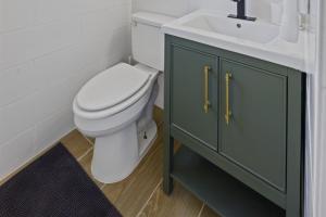 a bathroom with a white toilet and a sink at Whispering Oak- Lakefront Cabin Retreat in Madill +25 photos