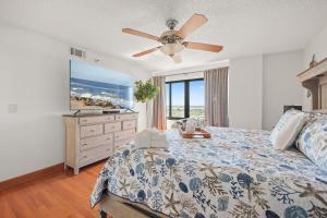 a bedroom with a bed and a ceiling fan at Oceanfront Penthouse 11b in Ormond Beach