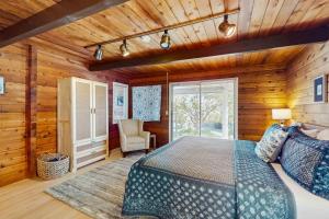 a bedroom with a bed in a room with wooden walls at Sea Side Cedar in Langley