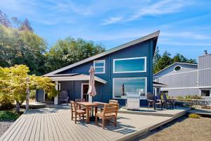 a blue house with a table and chairs on a deck at Sea Side Cedar in Langley