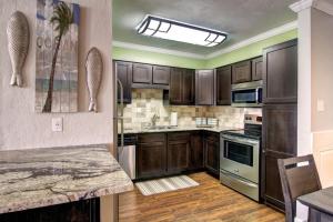 a kitchen with wooden cabinets and a counter top at Sand In Your Toes in Mustang Beach