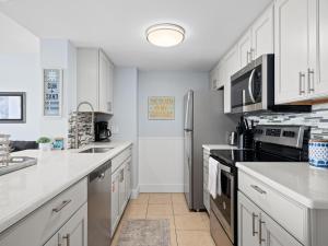 a kitchen with white cabinets and a stainless steel refrigerator at LR 309 - Ms, Annies Oasis in Rockport