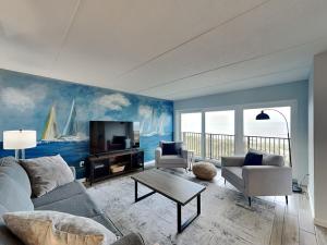 a living room with a couch and a tv at Beachcomber 403 in Jacksonville Beach