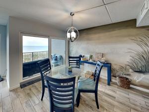 a dining room with a glass table and chairs at Beachcomber 403 in Jacksonville Beach
