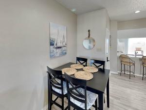 a dining room with a black table and chairs at Toes In The Water II in Padre Island