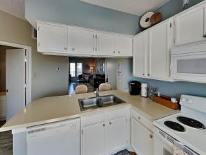 a kitchen with white cabinets and a sink at Toes In The Water II in Padre Island +28 photos