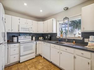 a white kitchen with white appliances and a window at La Dolce Vita Playa San Luis in Galveston +30 photos
