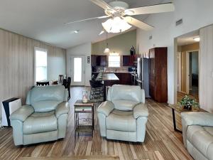a living room with two chairs and a ceiling fan at Seagulls Landing in Galveston