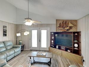 a living room with a couch and a flat screen tv at Seagulls Landing in Galveston