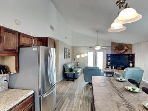 a kitchen with a refrigerator and a living room at Seagulls Landing in Galveston +39 photos