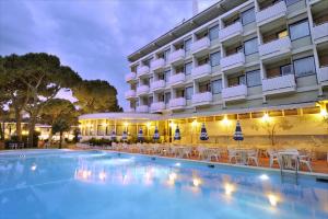 ein Hotel mit einem Pool vor einem Gebäude in der Unterkunft Hotel Medusa Splendid in Lignano Sabbiadoro