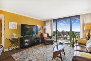 a living room with a large television and a couch and chair at San Luis Resort 533 - Luis Laid Back in Galveston