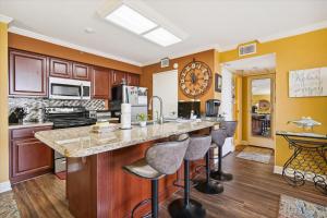 a kitchen with a large island with bar stools at San Luis Resort 533 - Luis Laid Back in Galveston +23 photos