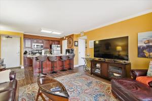 a living room with a couch and a kitchen at San Luis Resort 533 - Luis Laid Back in Galveston