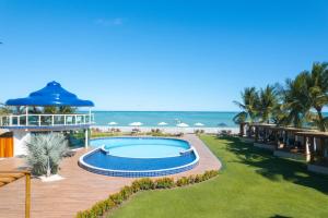a resort with a swimming pool next to the beach at Mansao in Maragogi