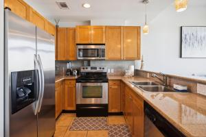 a kitchen with wooden cabinets and a stainless steel refrigerator at Emerald 705 in Galveston