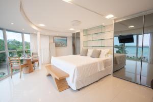 a bedroom with a bed and a table and a television at Mansao in Maragogi
