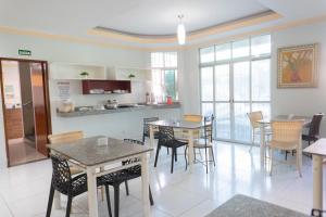a kitchen and dining room with tables and chairs at Hotel Oliveira in Goiânia