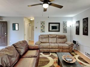 a living room with a couch and a ceiling fan at Knotty Pines Cabin in Ruidoso