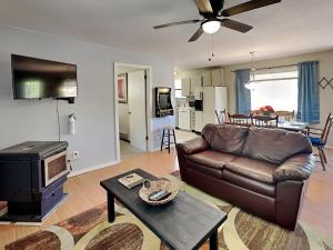 a living room with a leather couch and a table at Knotty Pines Cabin in Ruidoso