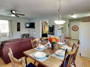 a dining room and living room with a table and chairs at Knotty Pines Cabin in Ruidoso +17 photos