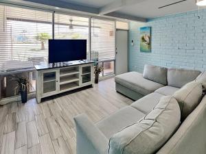 a living room with a couch and a flat screen tv at Sandy Shores in Port Aransas