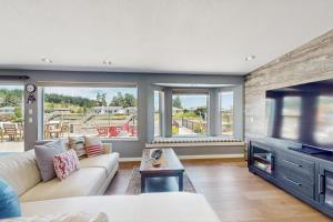 a living room with a couch and a tv at Whidbey Mariners’ Retreat in Oak Harbor