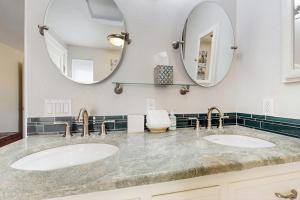 two sinks in a bathroom with two mirrors at Whidbey Mariners’ Retreat in Oak Harbor +17 photos