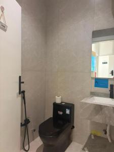 a bathroom with a black toilet and a sink at لين سويت in Khamis Mushayt