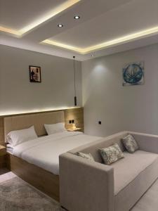 a bedroom with a large bed and a couch at لين سويت in Khamis Mushayt